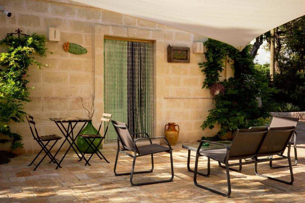 Terrazza con tavoli e piante a I Trulli del Tupparello