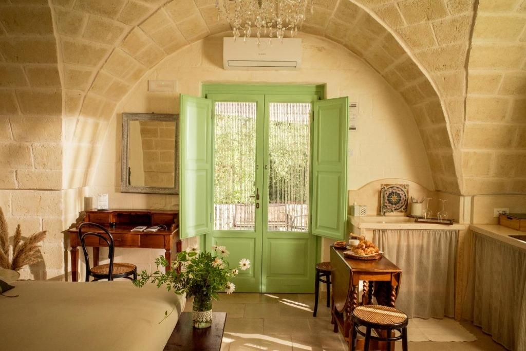 Interno di un trullo con volta in pietra e porte verdi
